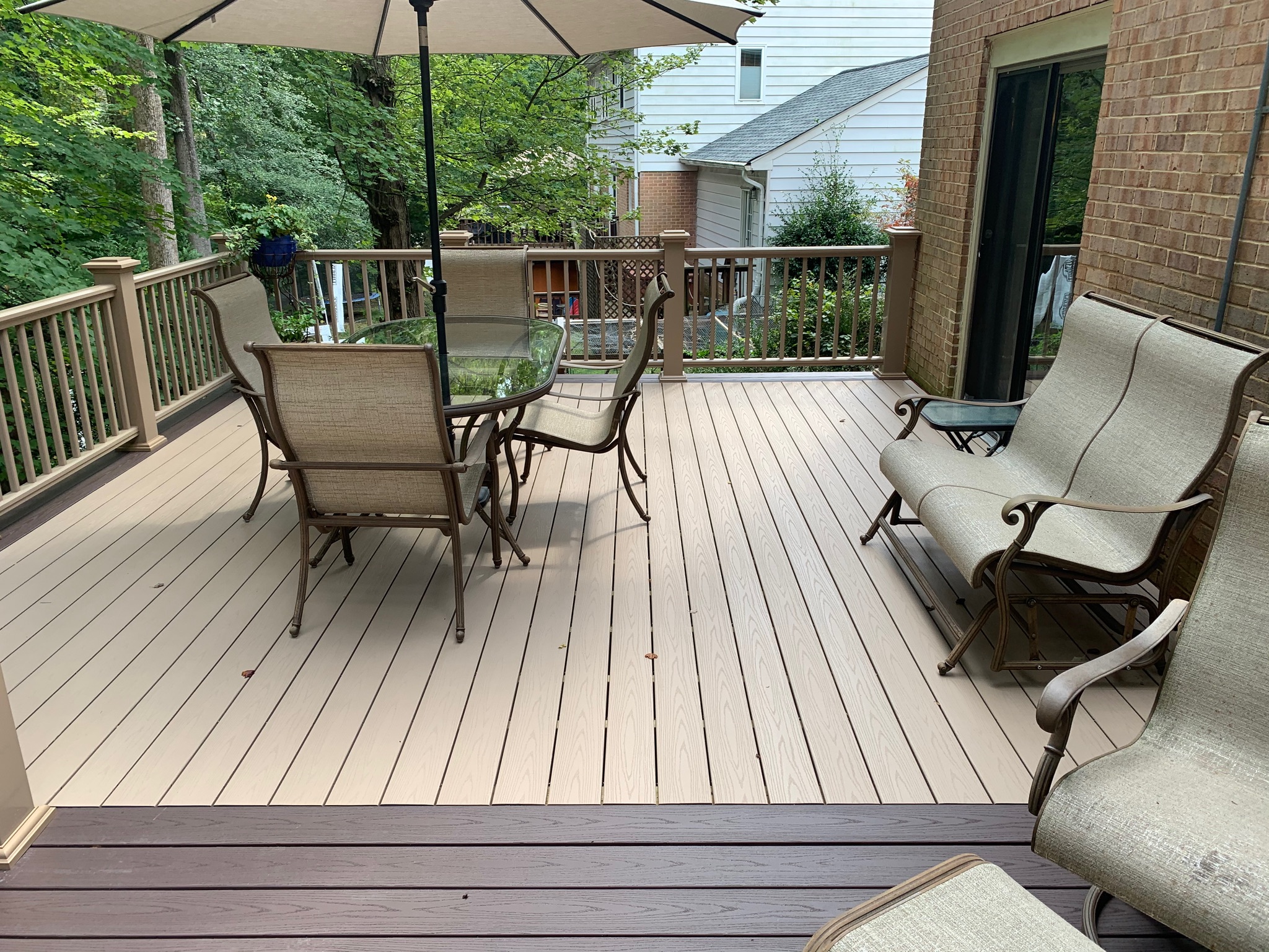 A wooden deck with chairs and an umbrella