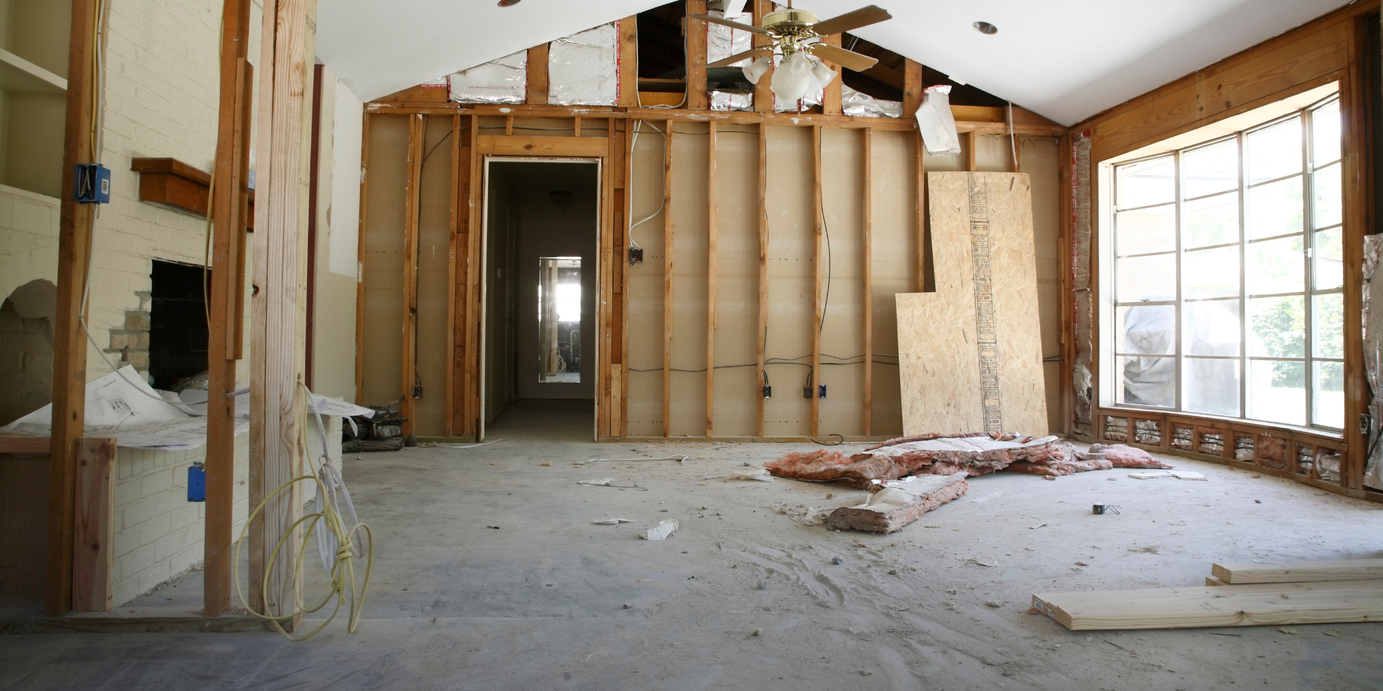 A room that is under construction with a ceiling fan