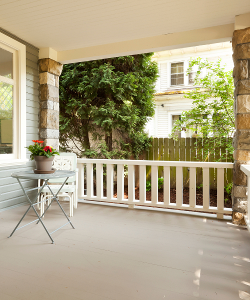 A porch with a table and chairs on it